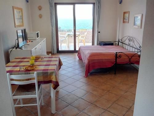 Habitación con cama, mesa y ventana en Splendido mono vista mare con wi fi a 100 mt da spiaggia, en Santa Teresa Gallura