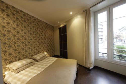 a bedroom with a bed and a large window at Apartment with strong WiFi and parking in Nice near the harbor in Nice