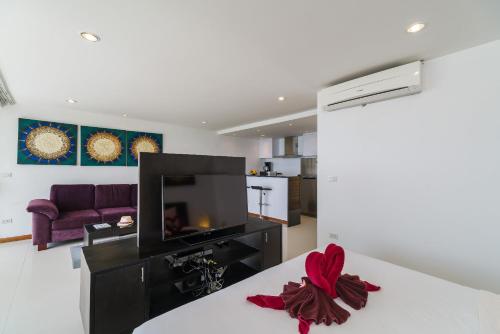 a living room with a tv and a couch at Tropical Sea View Residence in Lamai