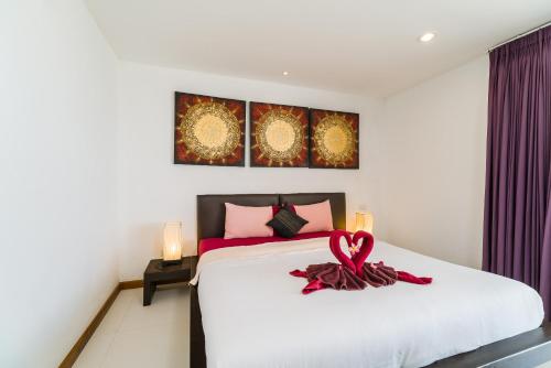 a bedroom with a bed with a red ribbon on it at Tropical Sea View Residence in Lamai