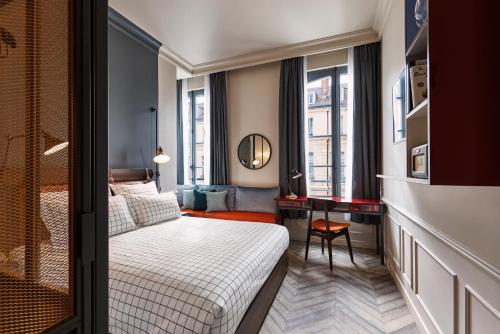 Cette chambre comprend un lit et un bureau. dans l'établissement The Hoxton, Paris, à Paris
