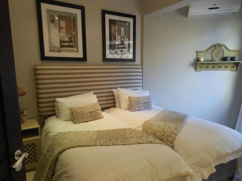 a bedroom with two beds and two pictures on the wall at 1 Marichel in Ballito