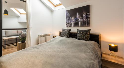 Un pat sau paturi într-o cameră la Downtown Apartments Cracow