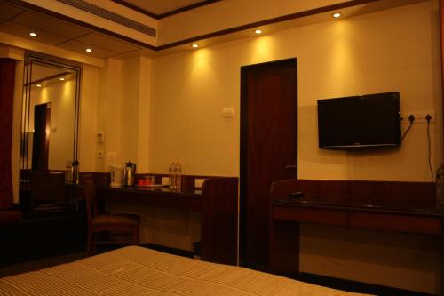 a hotel room with a bed and a television on the wall at Hotel Karl Residency in Mumbai