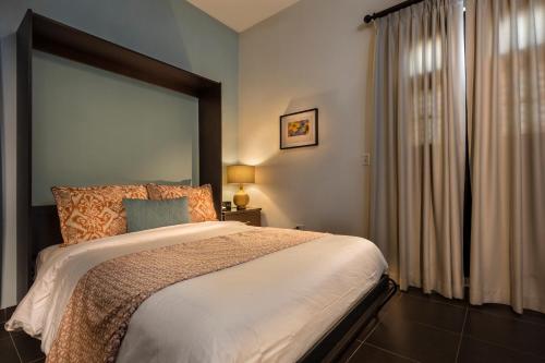 a bedroom with a bed and a large window at Decanter Hotel in San Juan