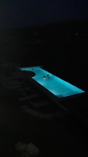 a lit up swimming pool in the dark at Luxurious villa at a unique spot in Agios Nikolaos