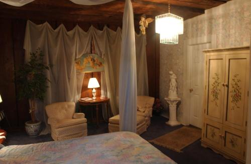 a bedroom with a bed and a chair and a lamp at Jailer's Inn in Bardstown