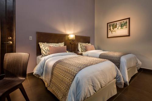 a hotel room with two beds and a chair at Decanter Hotel in San Juan