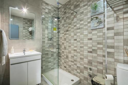 a bathroom with a shower and a sink and a toilet at Apartamento À Francos Balcony in Porto
