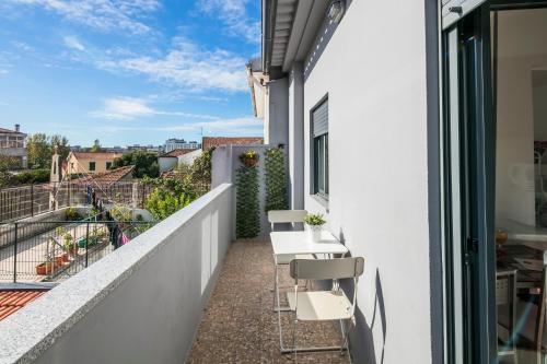 a balcony with white chairs on a white building at Apartamento À Francos Balcony in Porto