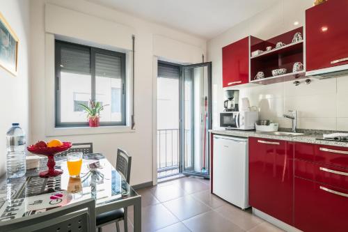 a kitchen with red cabinets and a counter top at Apartamento À Francos Gyn Lovers in Porto