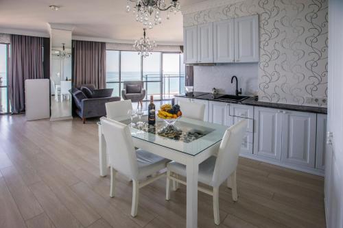een keuken en eetkamer met een tafel en stoelen bij Tina's Apartments with Panoramic Sea view in Batoemi