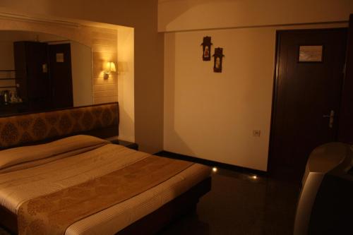 a hotel room with a bed and a mirror at Hotel Karl Residency in Mumbai