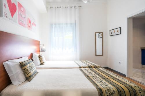 a bedroom with two beds and a window at Apartamento Garden Avenue in Porto