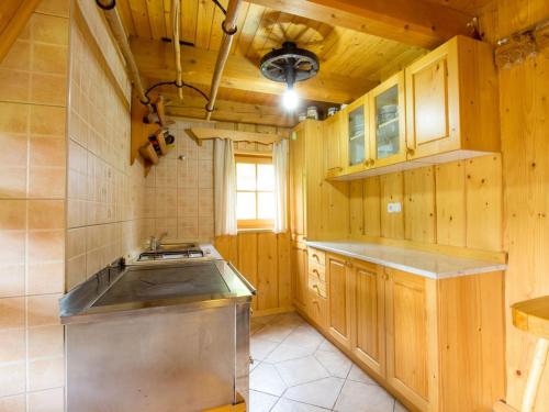 a kitchen with wooden cabinets and a sink and a stove at Hiška vogar in Bohinj