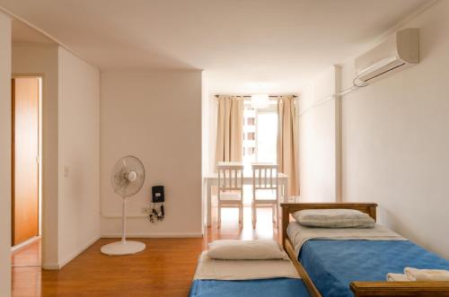 a bedroom with two beds and a fan and a window at Apartamento Obispo Trejo IV by Lofty in Cordoba