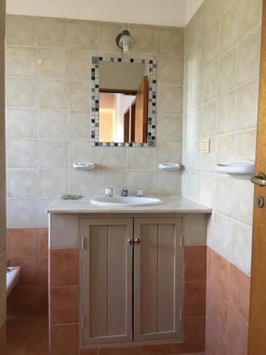 a bathroom with a sink and a mirror at Residencial del Golf in Alta Gracia