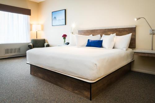 a hotel room with a large bed and a chair at Harbor 360 Hotel Seward in Seward