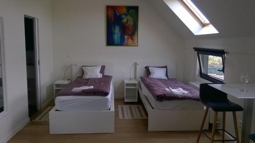 um quarto com duas camas e uma mesa e uma janela em B&B Wannes Suite em Lovaina