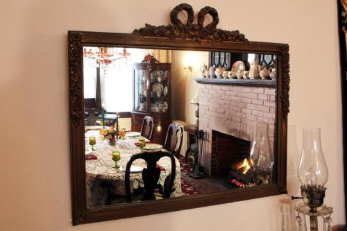 espejo que refleja una sala de estar con chimenea en Luther Ogden Inn, en Cape May