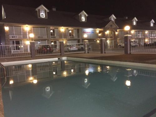 a swimming pool in front of a building at night at Interstate Inn in Roland