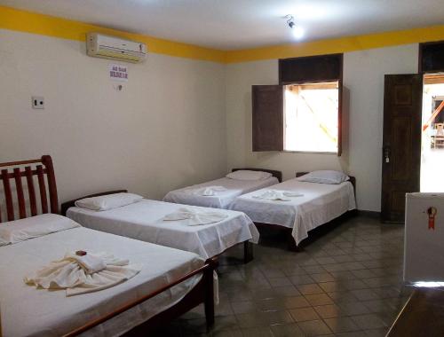 a group of three beds in a room at Toca do Vaidoso in Barreirinhas