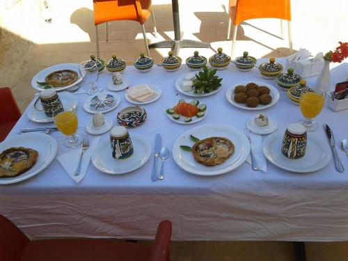 a white table with plates of food on it at Dar Sitti Aziza in Bethlehem