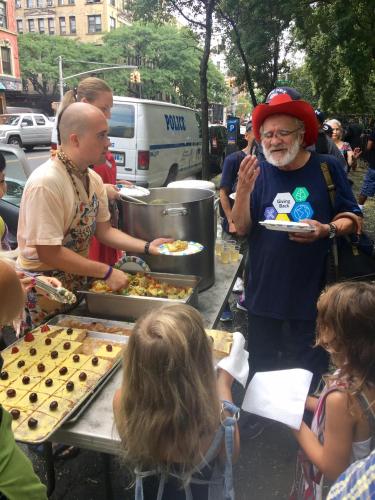 a man holding a plate of food at a picnic table at Interfaith Retreats in New York