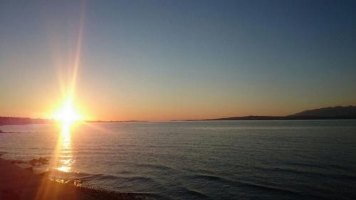 a sunset over a body of water with the sun setting at Apartments Barbara 111 in Vir