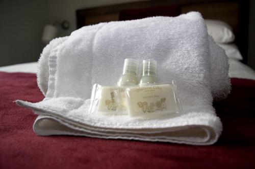 due bottiglie di sapone poggiate sopra un asciugamano di Ravine Hotel a Lisdoonvarna