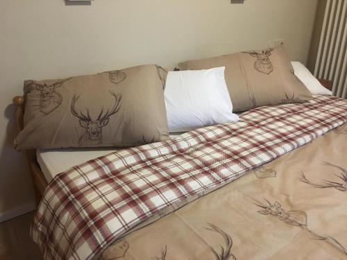 a bed with pillows with deer heads on it at Pension Bergseeblick in Titisee-Neustadt