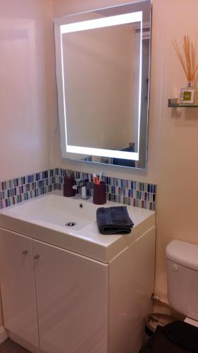 a bathroom with a white sink and a mirror at Clover Cottage in Winster