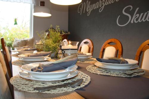 a long table with white plates on top of it at Młynarzowa Chata in Lesko