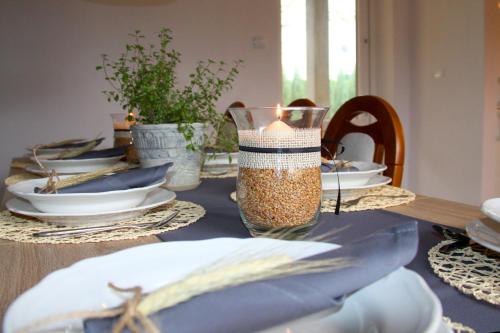 a dining room table with a candle and plates at Młynarzowa Chata in Lesko