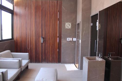 a bathroom with a shower and a couch and a sink at HOLANDAS PRIME TAMBAU Flat in João Pessoa