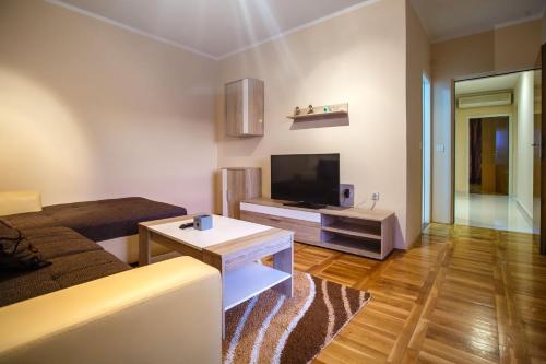 a living room with a couch and a flat screen tv at Apartments Slavko in Supetarska Draga