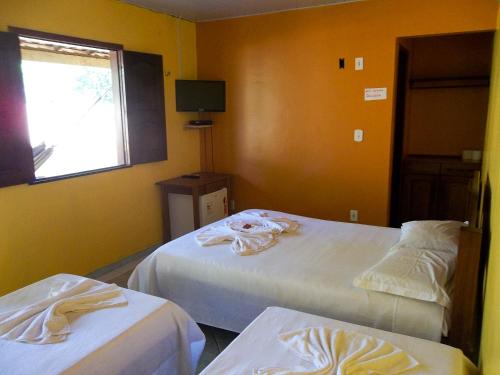 a hotel room with two beds and a window at Toca do Vaidoso in Barreirinhas