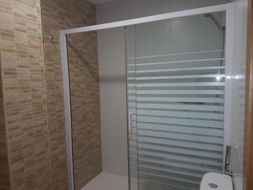 a glass shower in a bathroom with a toilet at Casa Esquilador in Navarrés