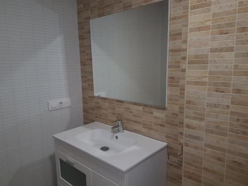 a bathroom with a white sink and a mirror at Casa Esquilador in Navarrés