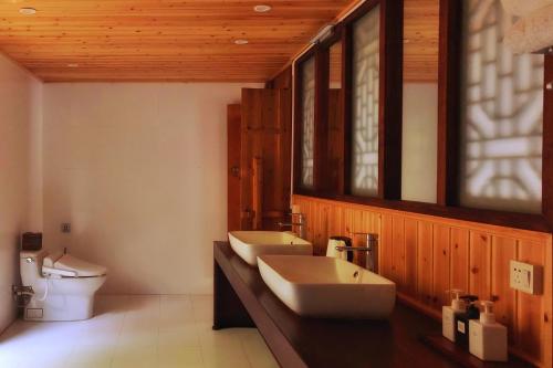 a bathroom with two sinks and a toilet at Zen Box House in Yangshuo