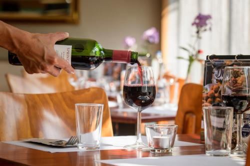 een persoon die wijn in een glas giet op een tafel bij Campanile Hotel & Restaurant Vlaardingen in Vlaardingen