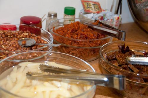 a table topped with glass bowls filled with food at Hua Tong Hotel in Hualien City