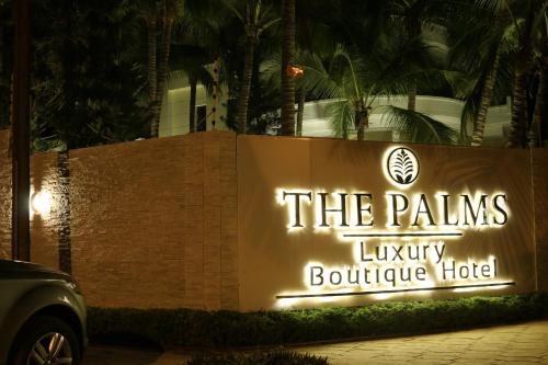a sign for the palms luxury boutique hotel at night at THE PALMS Luxury Boutique Hotel in Dakar