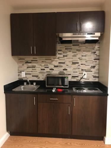 a kitchen with a sink and a microwave at Econo Lodge Inn & Suites Houston Willowbrook in Houston