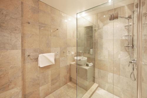 a bathroom with a glass shower with a toilet at Alderly Apartment 10, Little Cove in Noosa Heads