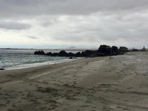 an empty beach with rocks in the water at Hostal CKAIR in Bahia Inglesa