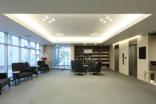 a waiting room with chairs and tables in a building at Kuretake Inn Premium Nagoya Nayabashi in Nagoya