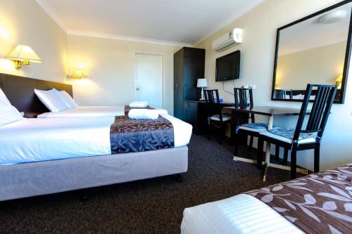 a hotel room with two beds and a desk at Abcot Inn in Sylvania
