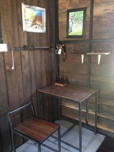 Cette chambre en bois comprend une table et une chaise. dans l'établissement The Shadow House & Bar, à Ko Phayam