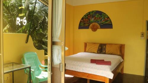 a small bedroom with a bed and a chair at Island Lodge in Ko Chang